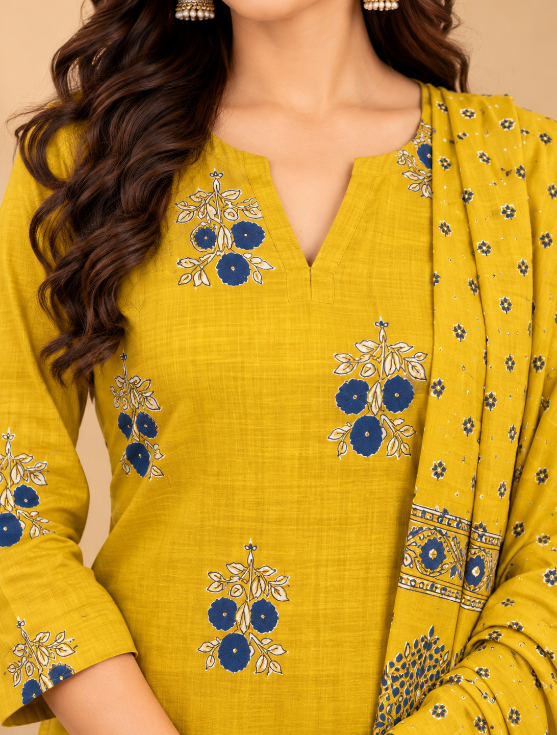 Mustard yellow kurta pant set with blue and cream floral prints and matching dupatta featuring a decorative border.