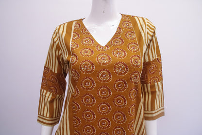 Mannequin wearing a patterned brown and beige top on a white background