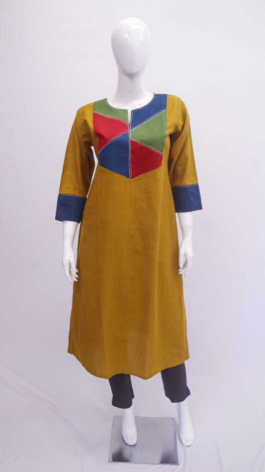 Mustard yellow dress with colorful geometric patterns on a mannequin against a white background