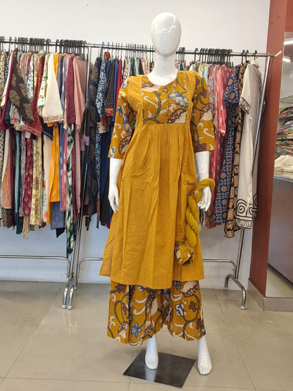 Mannequin wearing a mustard yellow dress with floral patterns in a clothing store.