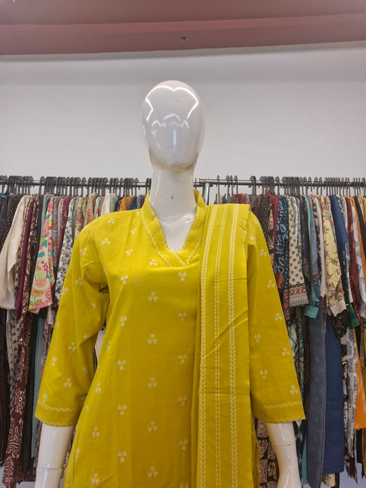 Mannequin wearing a yellow kurta with floral patterns in a clothing store.