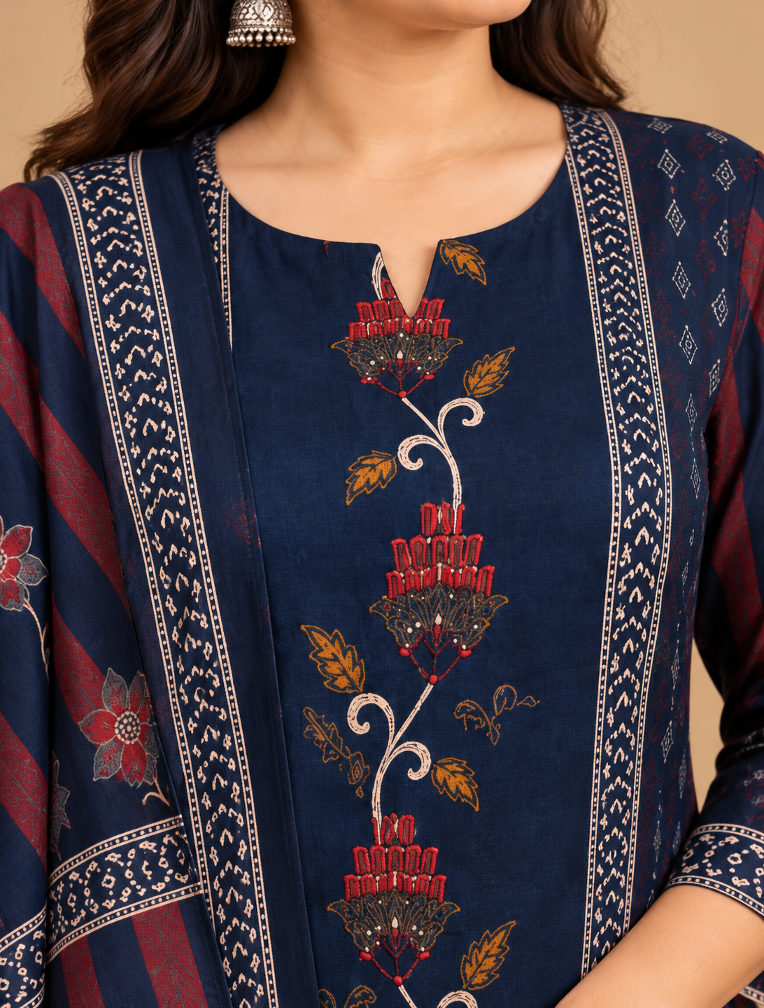Navy blue kurta pant set with traditional floral motifs, decorative printed borders, matching pants and maroon striped dupatta with tassels, displayed on a female model.