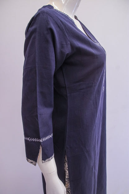 Navy blue dress with white embroidery on a mannequin against a light purple background