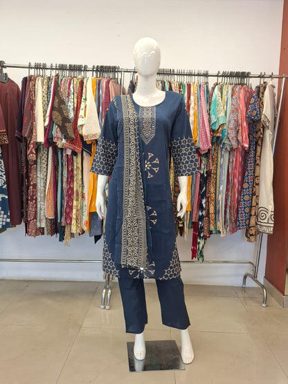 Mannequin wearing a blue embroidered outfit in a clothing store.