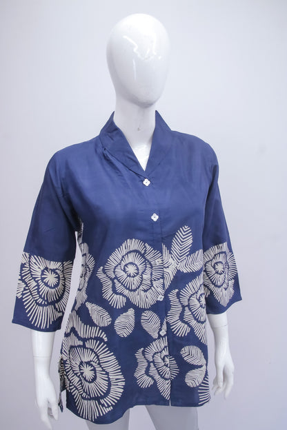 Blue shirt with white floral patterns on a mannequin against a white background