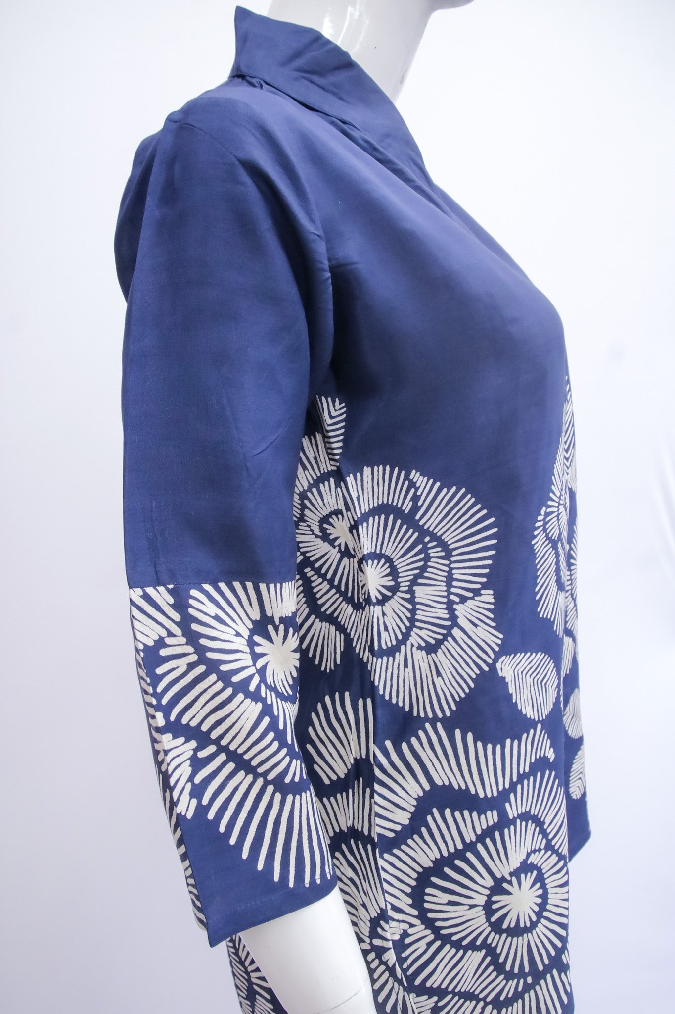 Blue jacket with white floral pattern on a mannequin against a white background