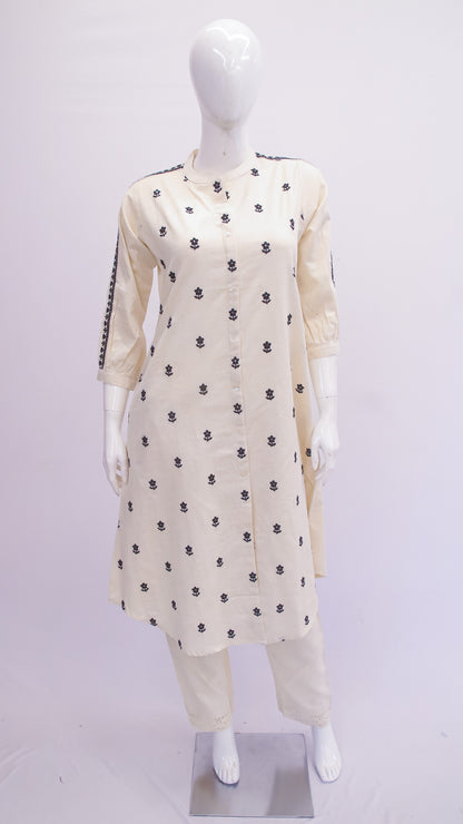 Mannequin wearing a white outfit with black patterns on a white background