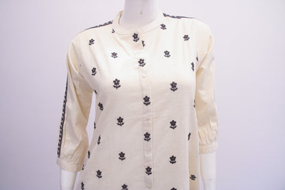 White blouse with black floral patterns on a mannequin against a white background