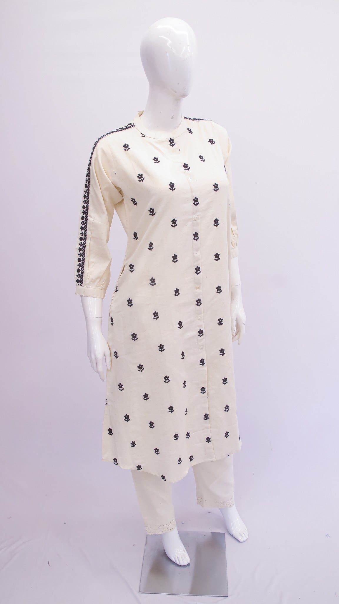 White kurta with black patterns on a mannequin against a white background
