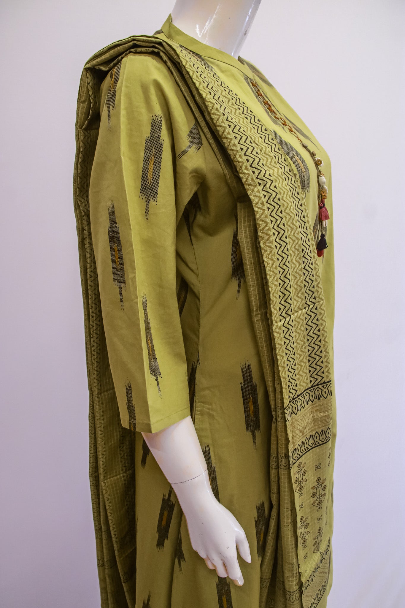 Green patterned garment on a mannequin against a white background