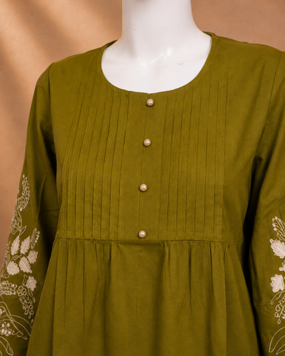 An olive green long-sleeve tunic top with vertical pleats on the bodice, a round neckline, decorative pearl-like buttons down the front, and white floral embroidery on the sleeves, displayed on a white mannequin torso.