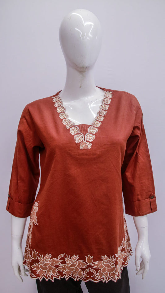 Red blouse with white lace details on a mannequin against a white background