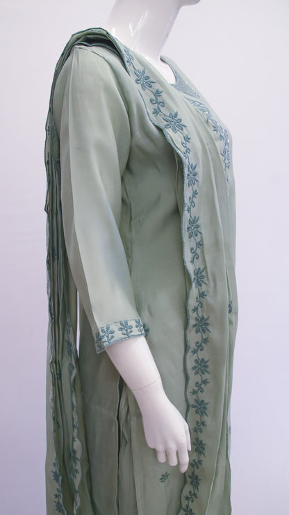 Mannequin wearing a green dress with floral embroidery on a white background