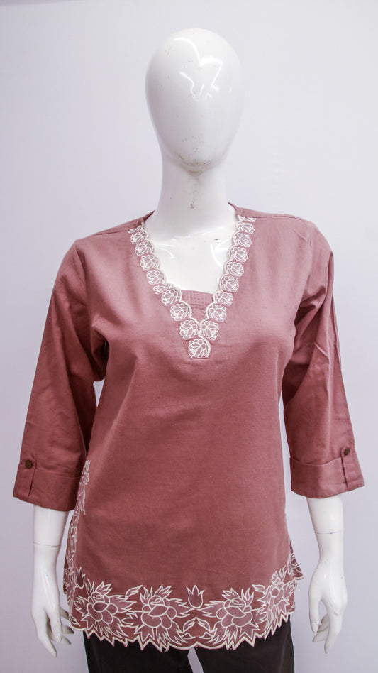 Mauve blouse with lace details on a mannequin against a white background