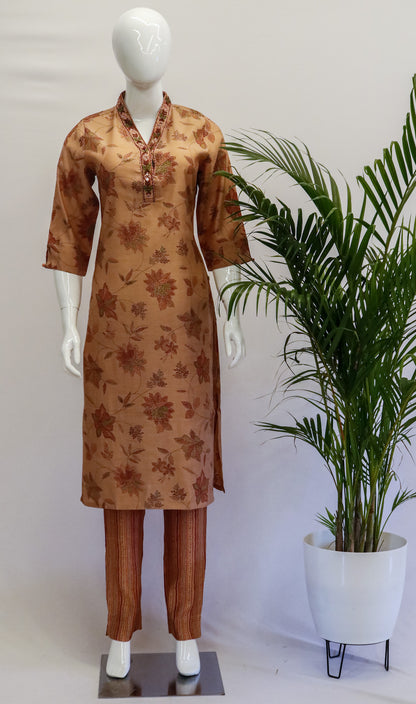 A mannequin wearing a peach-colored floral muslin top and pants with a V-neck and 3/4th sleeves.