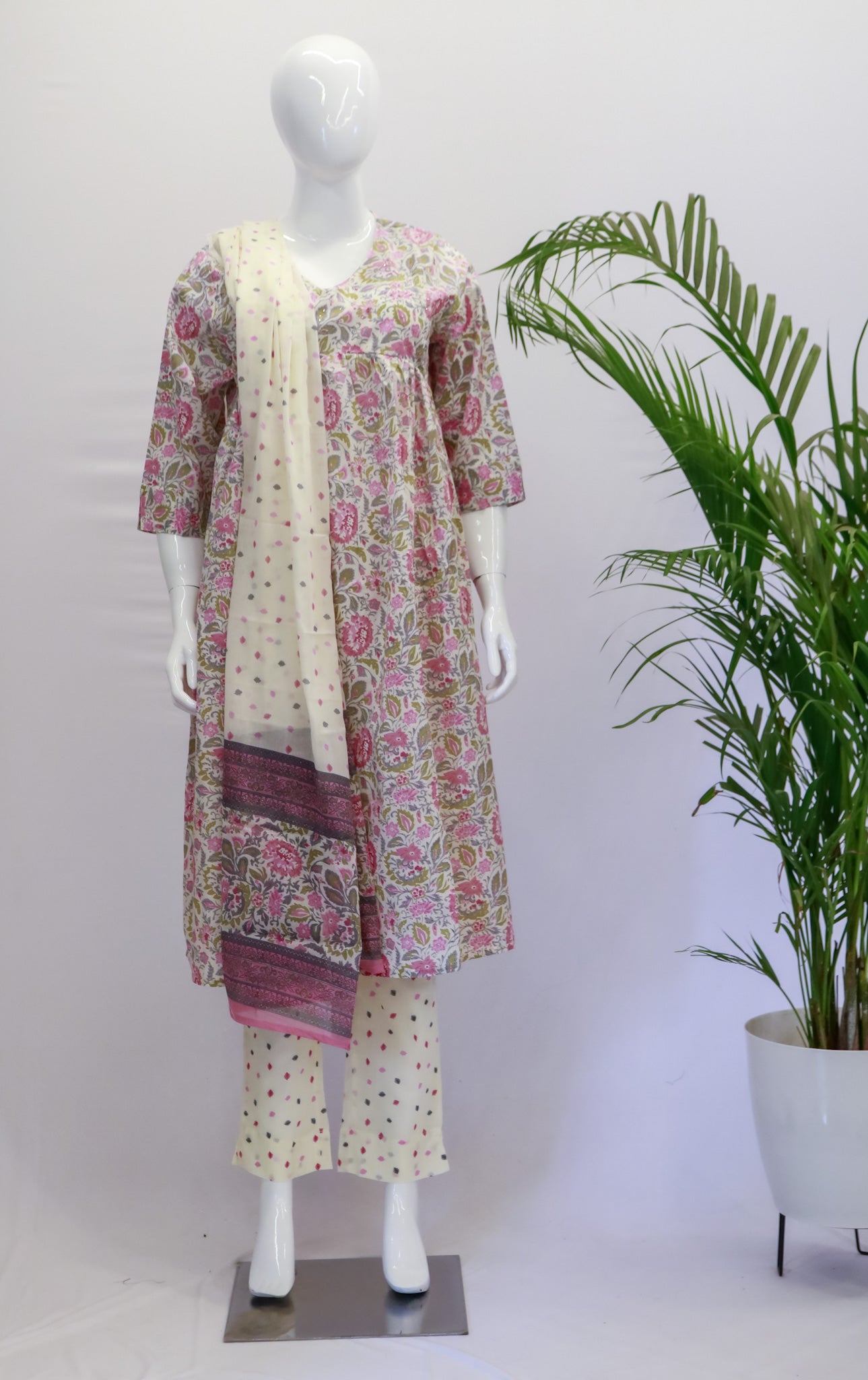 A mannequin displaying a pink cotton Anarkali dupatta set with floral prints, consisting of a kurta, pants, and dupatta.