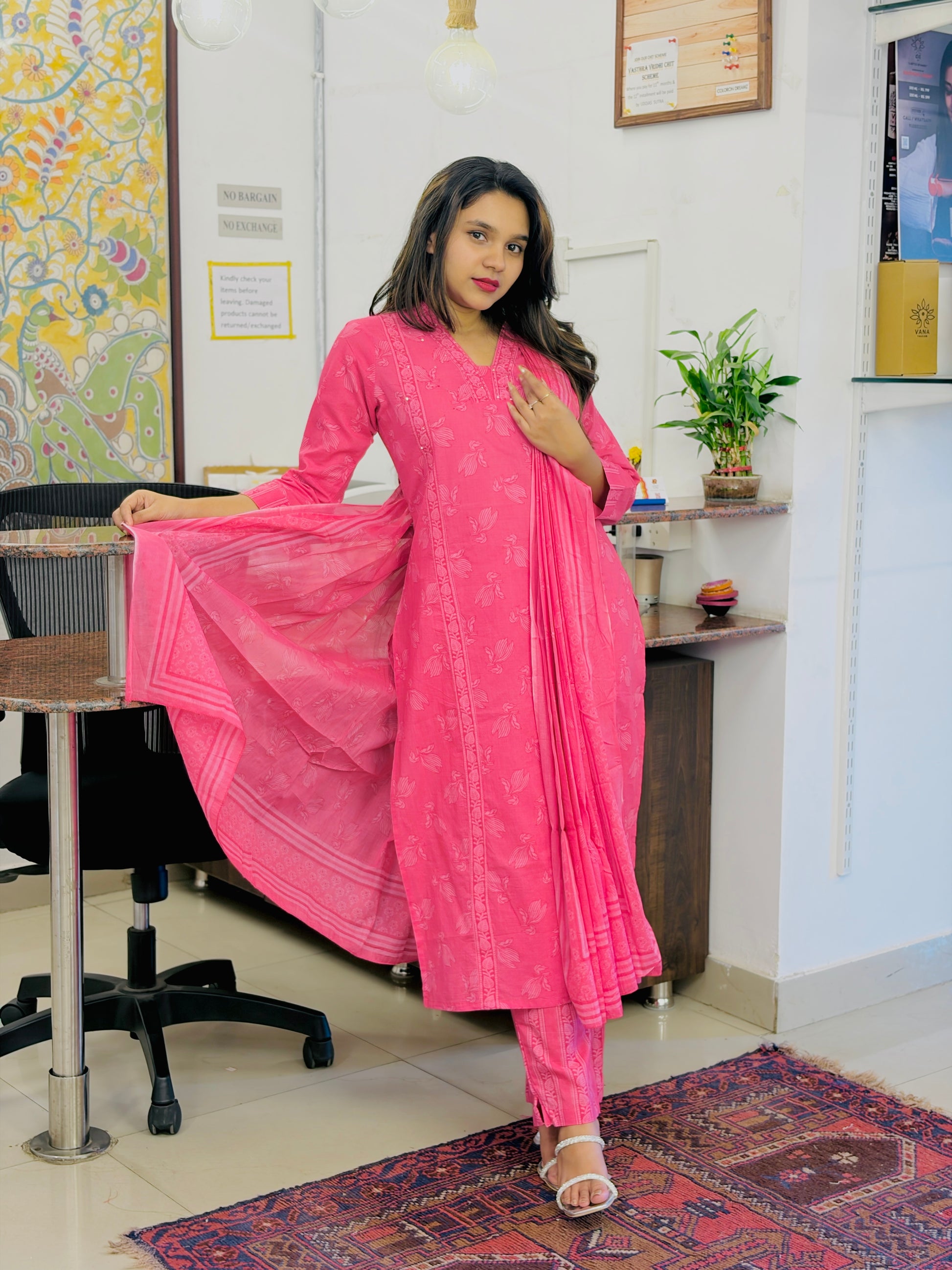 Woman in a pink traditional outfit standing in an office setting