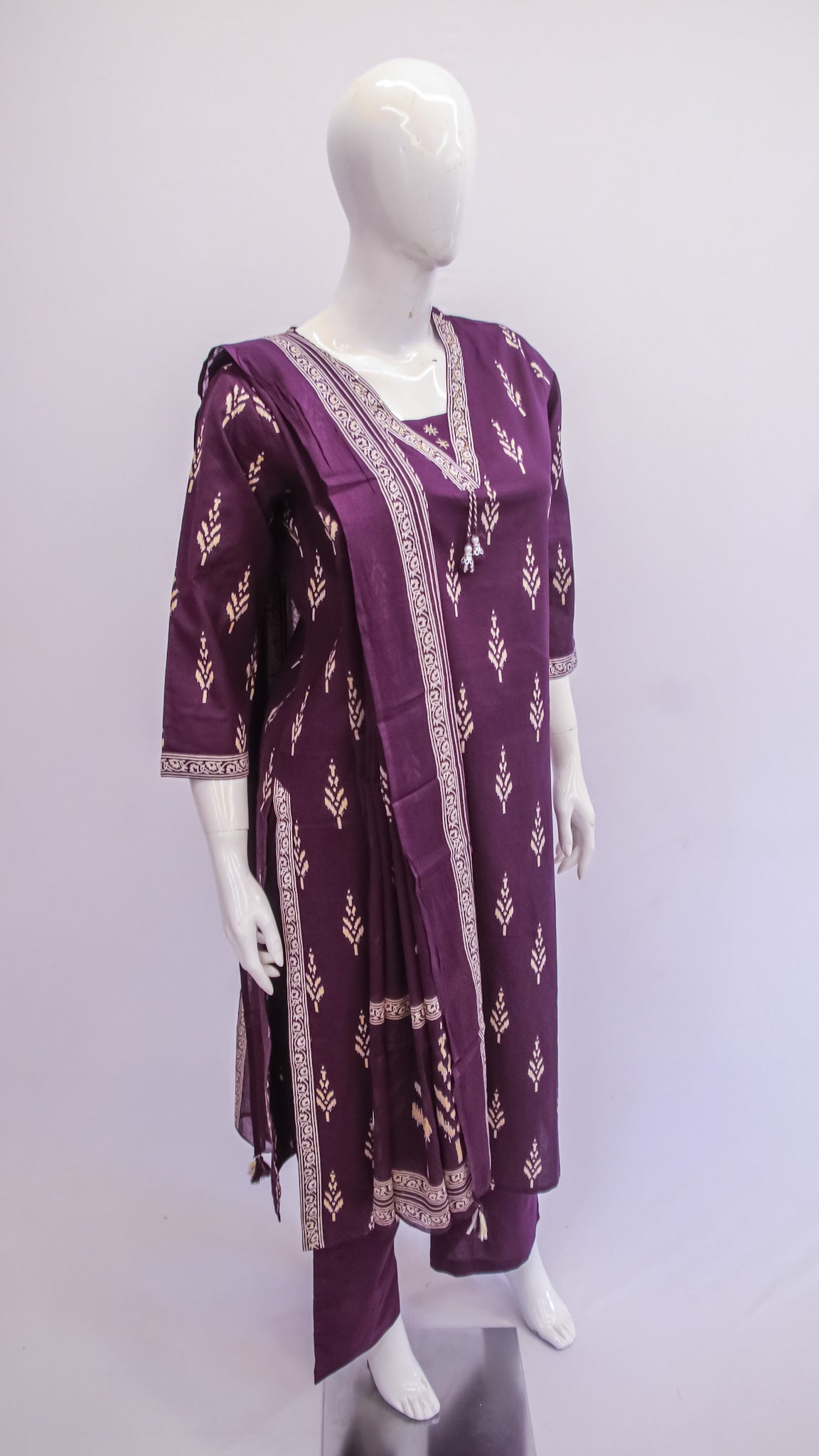 Purple embroidered outfit on a mannequin against a white background