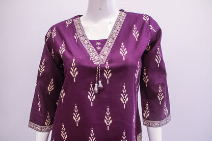 Purple traditional top with white patterns on a mannequin against a white background