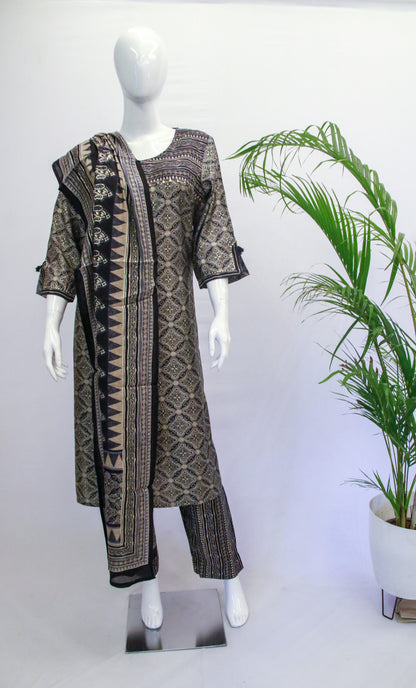 A mannequin displaying a grey and black floral printed kurta with three-quarter sleeves and a round neck, paired with straight-leg pants and a matching dupatta with prints.