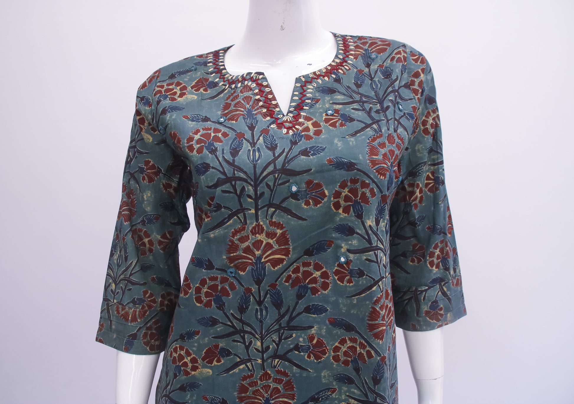 Floral patterned top on a mannequin against a white background