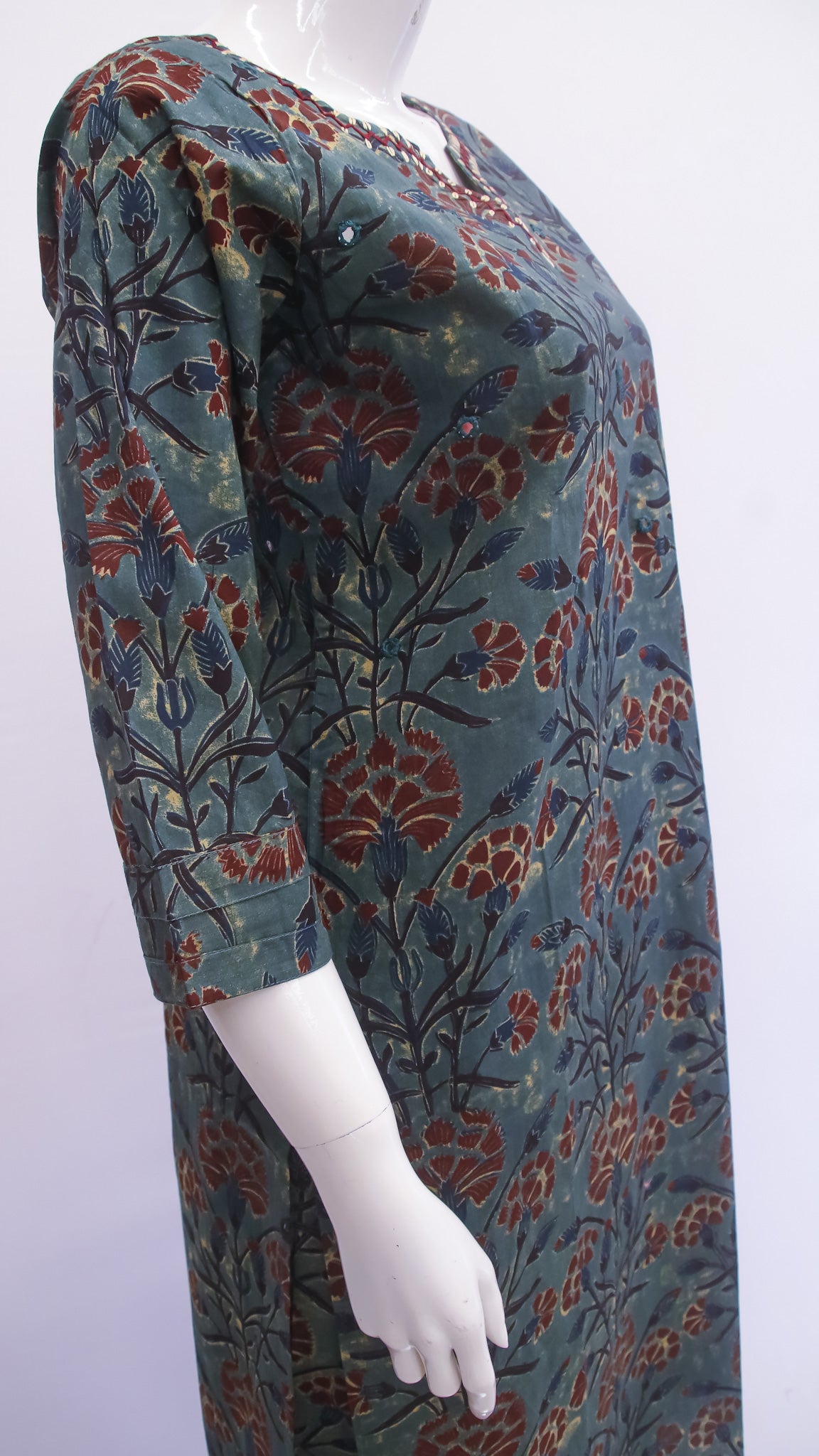 Mannequin wearing a long-sleeve dress with a floral pattern on a white background