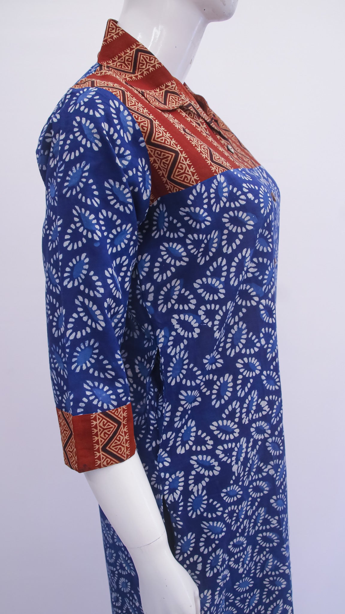 Mannequin wearing a blue and red patterned shirt on a white background