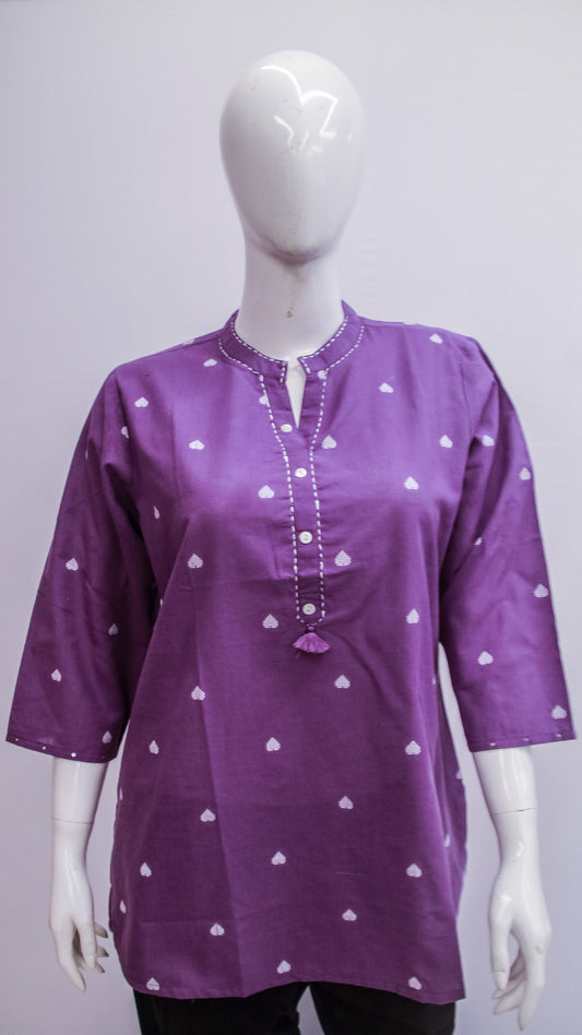 Purple shirt with white heart patterns on a mannequin against a gray background