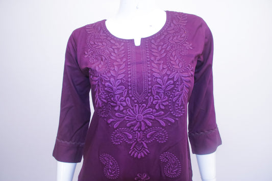 Purple embroidered dress on a mannequin against a white background