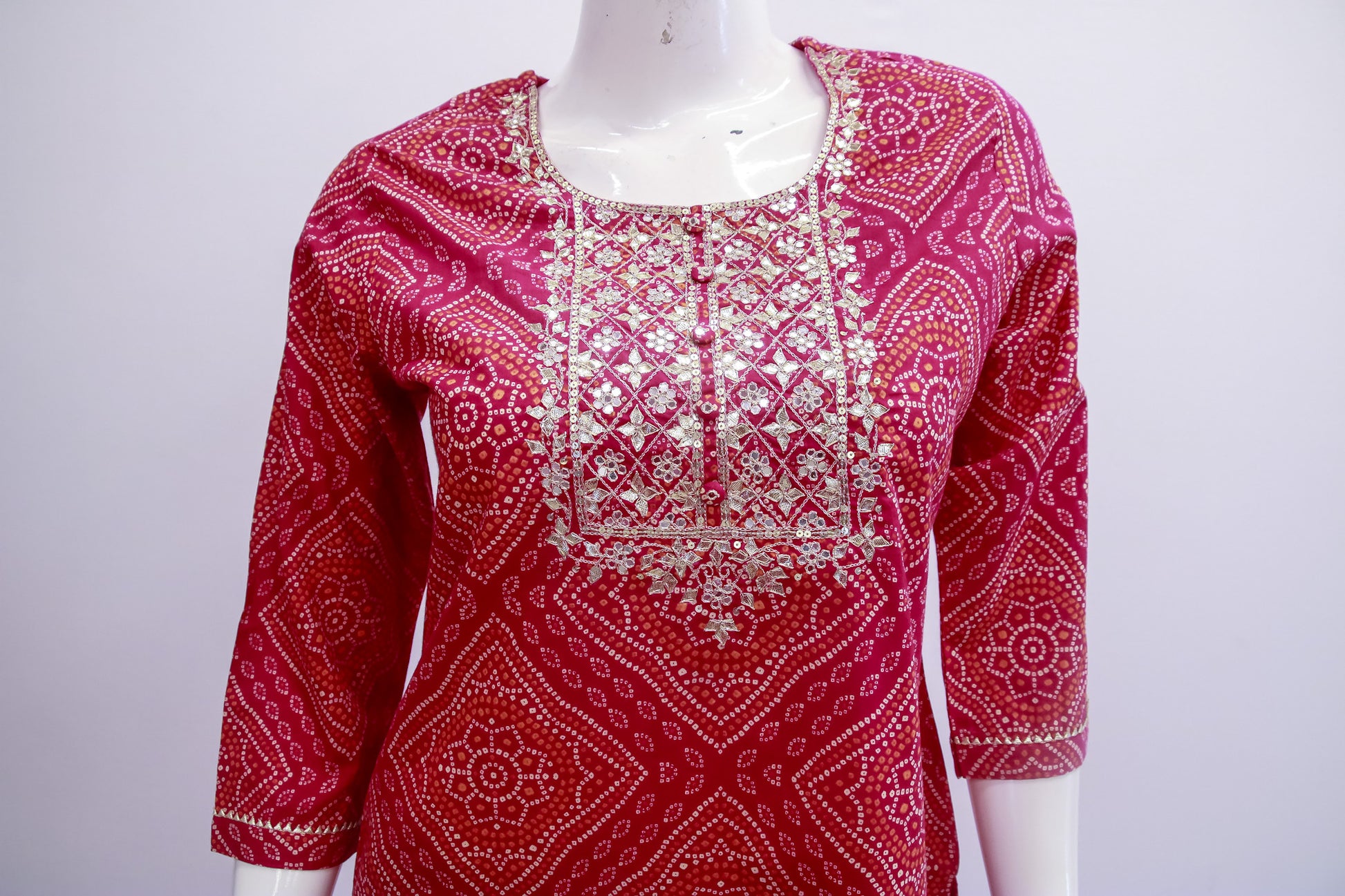 Red patterned top on a mannequin against a white background