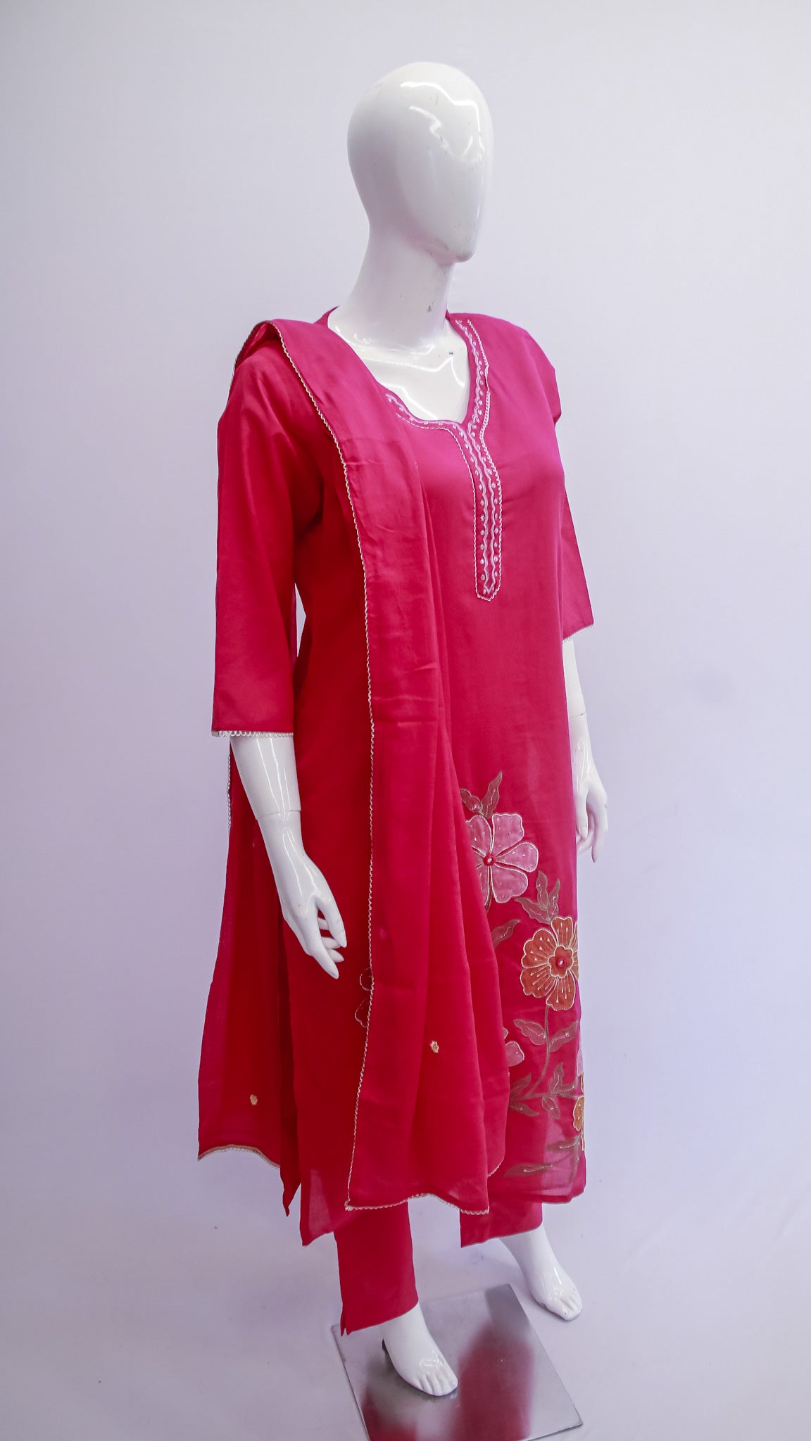 Red embroidered kurta set on a mannequin against a white background