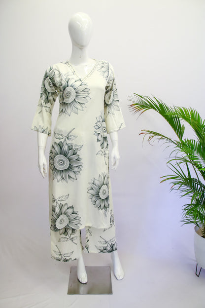 Mannequin wearing a floral dress with a white background and plant decoration.