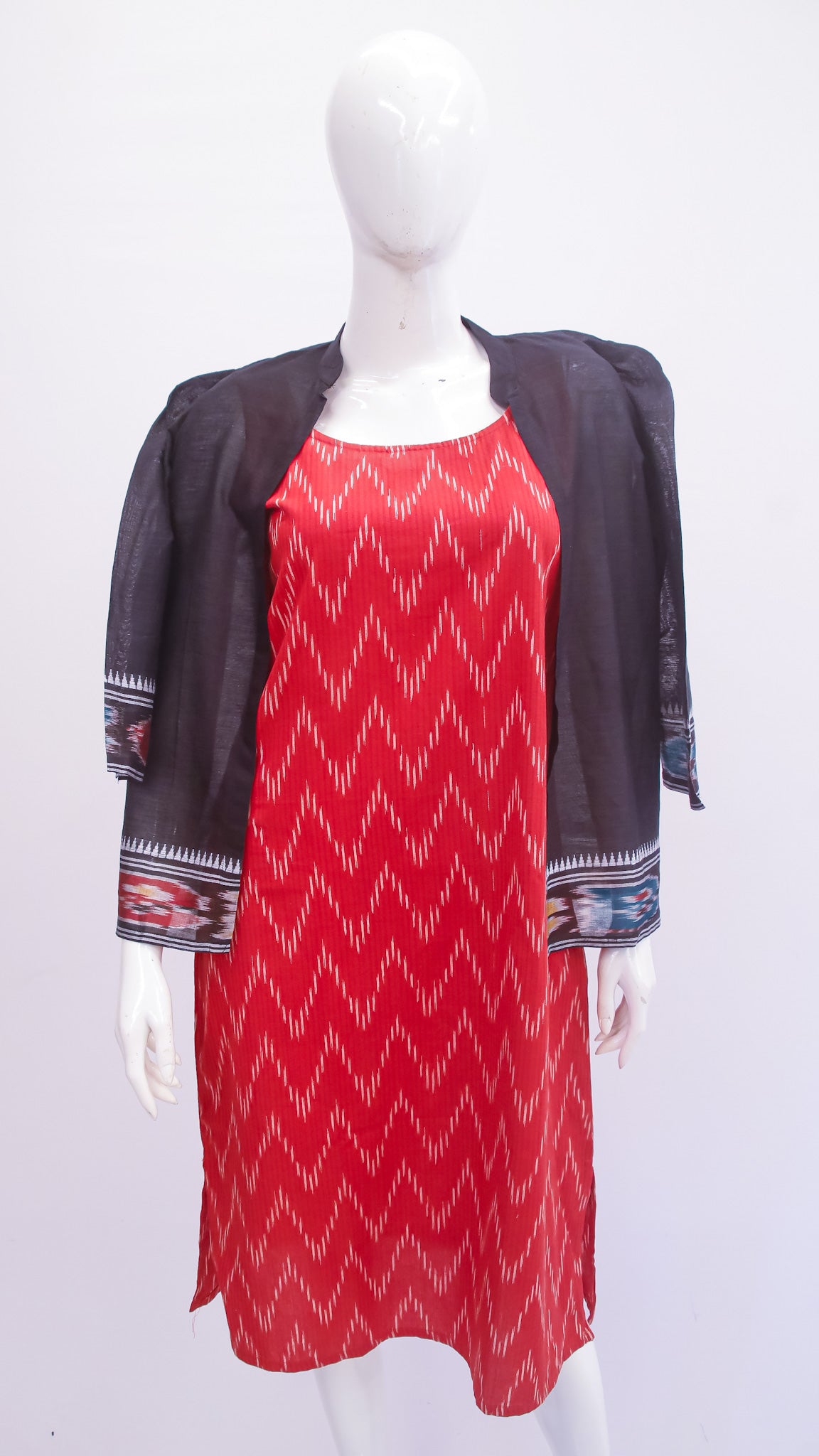 Red patterned dress with a black jacket on a mannequin against a white background