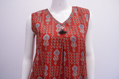Red patterned sleeveless top on a mannequin against a white background