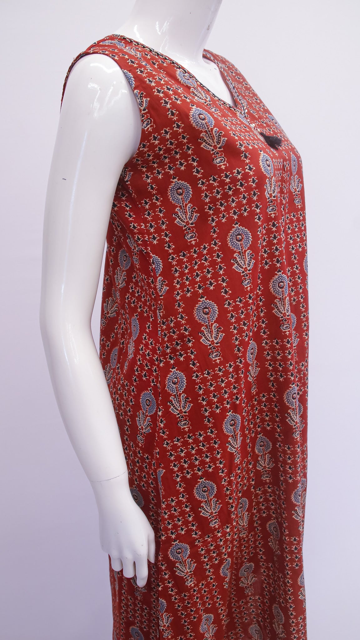 Red patterned dress on a mannequin against a white background