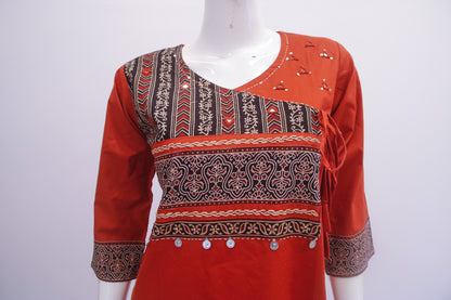 Red patterned blouse on a mannequin against a white background
