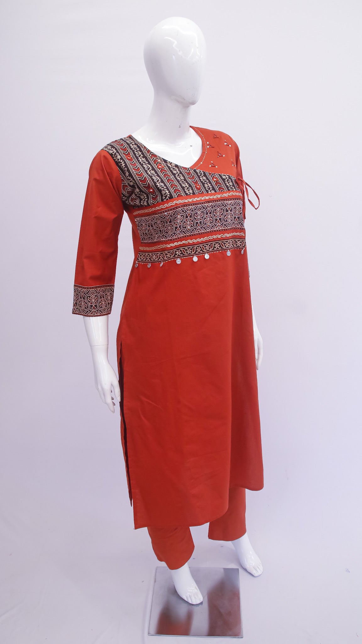 Red kurta with intricate patterns on a white mannequin against a white background