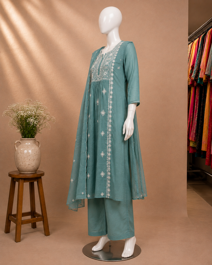 A teal green ethnic kurta set with matching trousers displayed on a white mannequin. The set features white embroidery on the chest and down the front center.