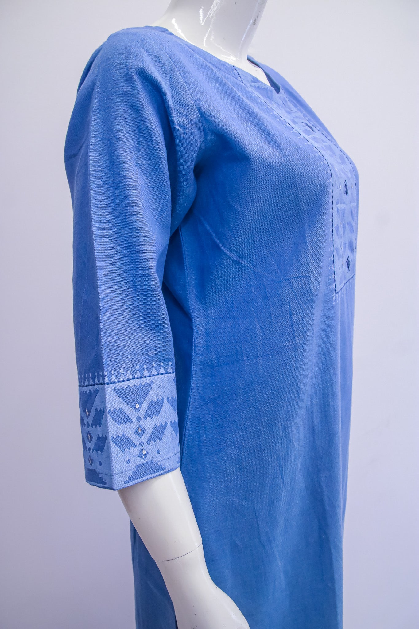 Blue embroidered dress on a mannequin against a white background