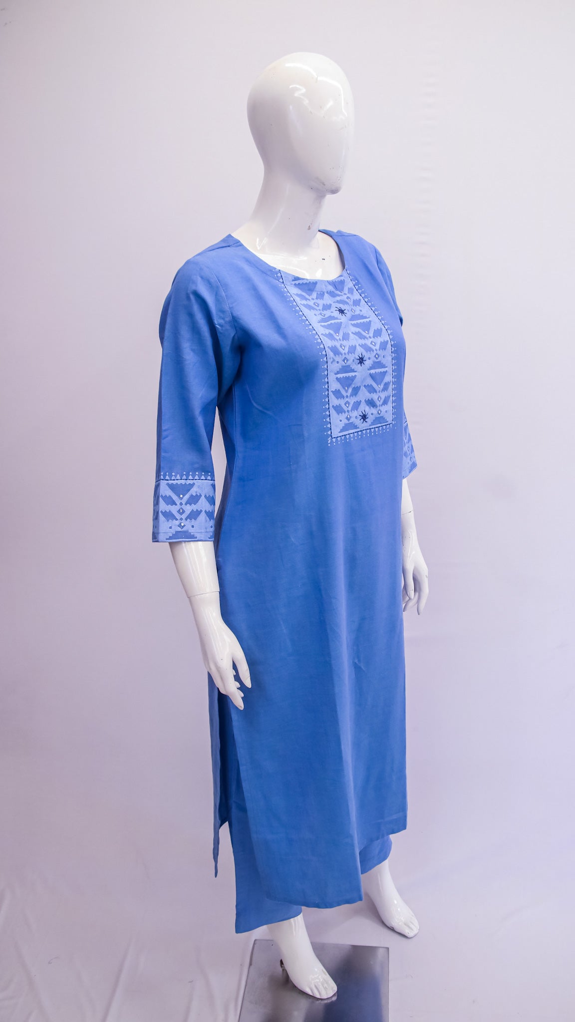 Blue embroidered dress on a mannequin against a white background