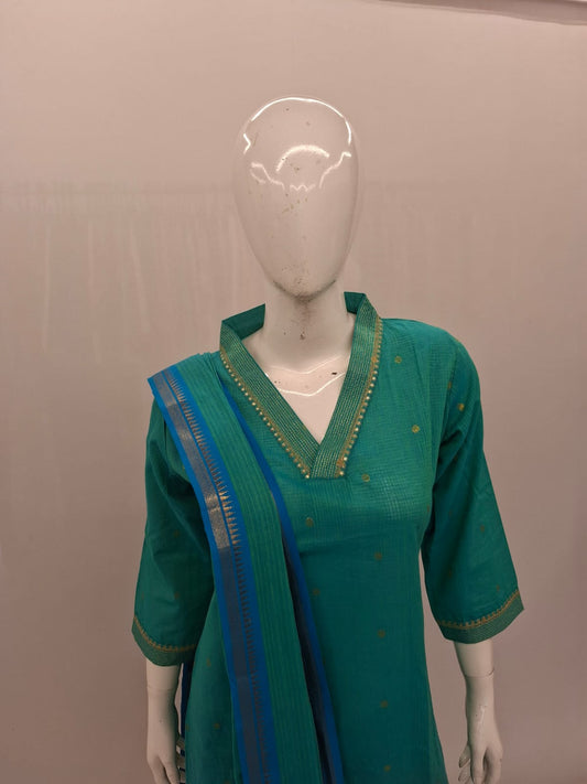 Green traditional outfit with blue accents on a mannequin against a plain background