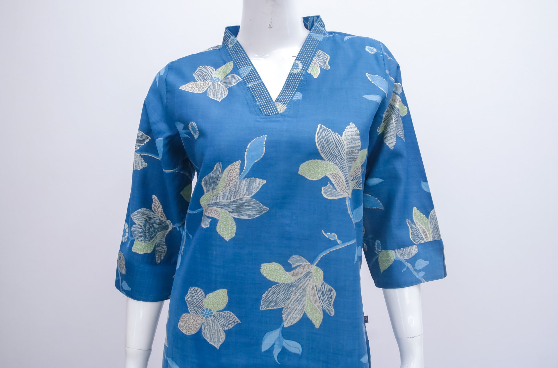 Blue floral patterned shirt on a mannequin against a white background