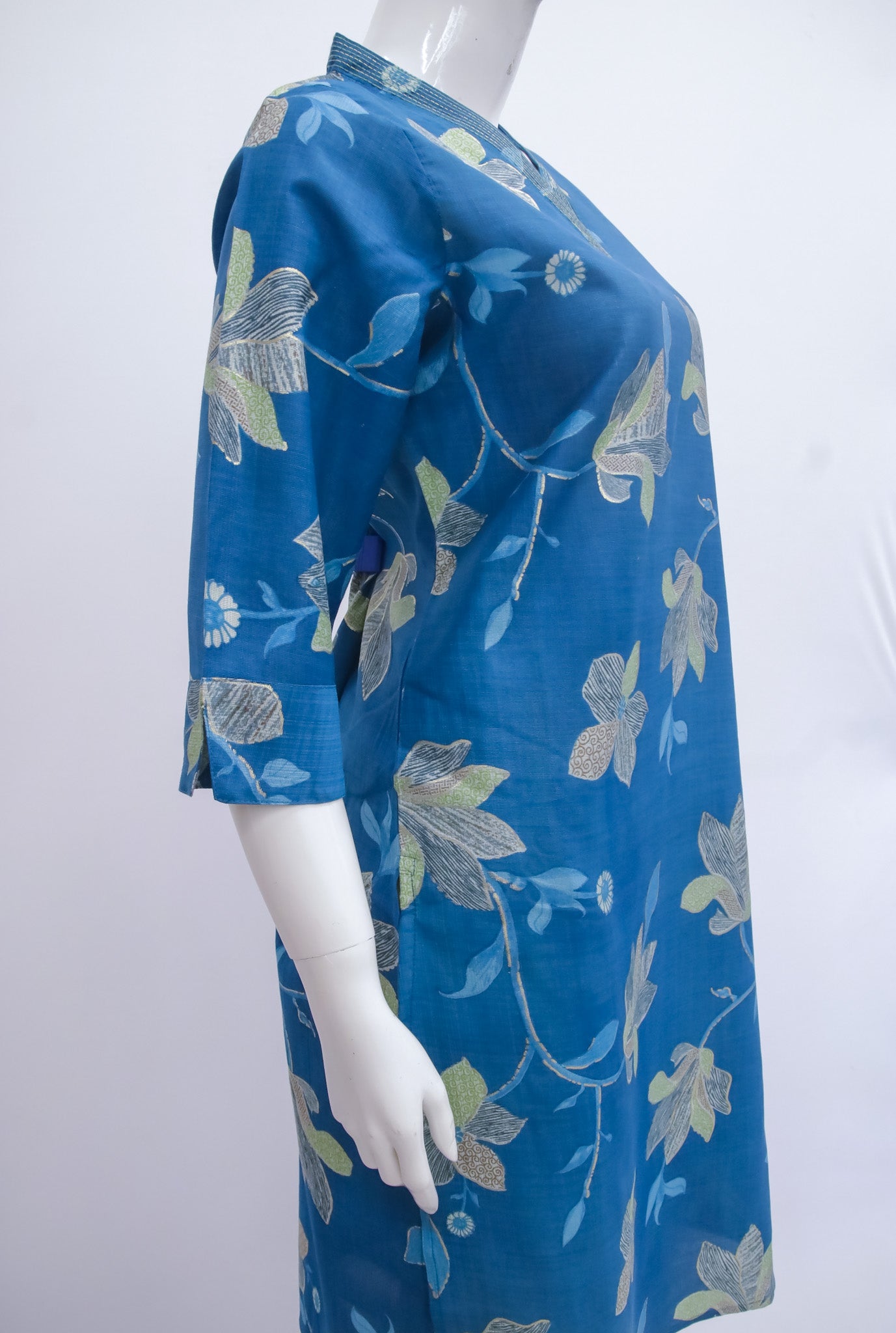 Blue floral dress on a mannequin against a white background