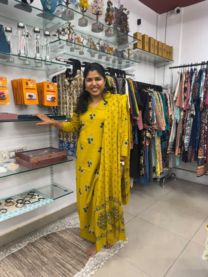 Mustard yellow kurta pant set with blue and cream floral prints and matching dupatta featuring a decorative border.