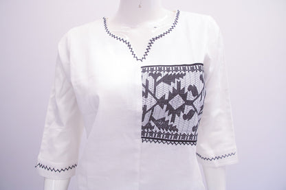 White sweater with black geometric pattern on a mannequin against a white background