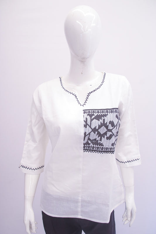 White blouse with black pattern on a mannequin against a white background