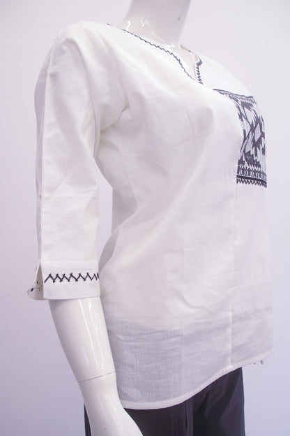 White blouse with black embroidery on a mannequin against a white background