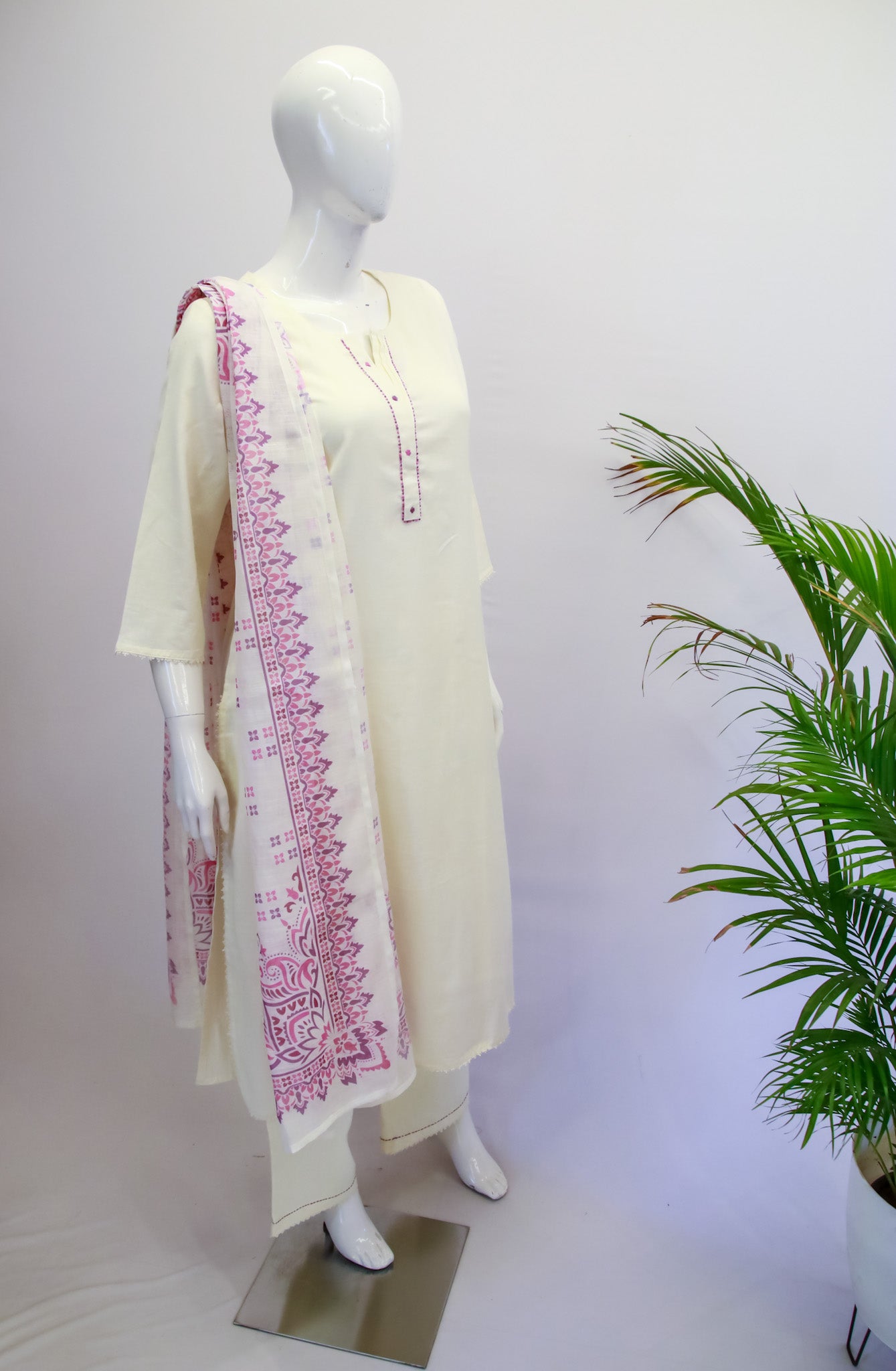Mannequin wearing a cream kurta with pink embroidery against a white background