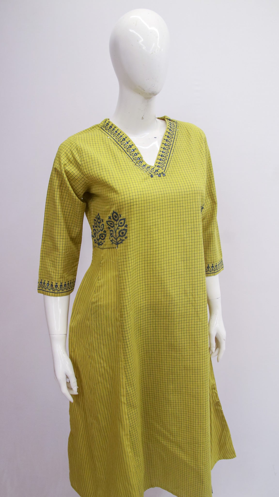 Yellow checkered kurta with embroidery on a white mannequin against a light gray background