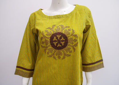 Yellow dress with brown pattern on a mannequin against a white background